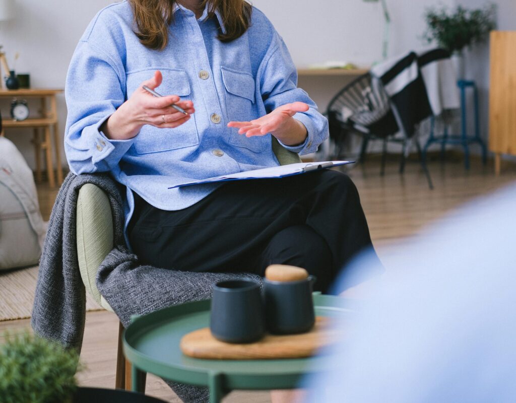 A therapist consults with a client in a contemporary office, focusing on mental health.